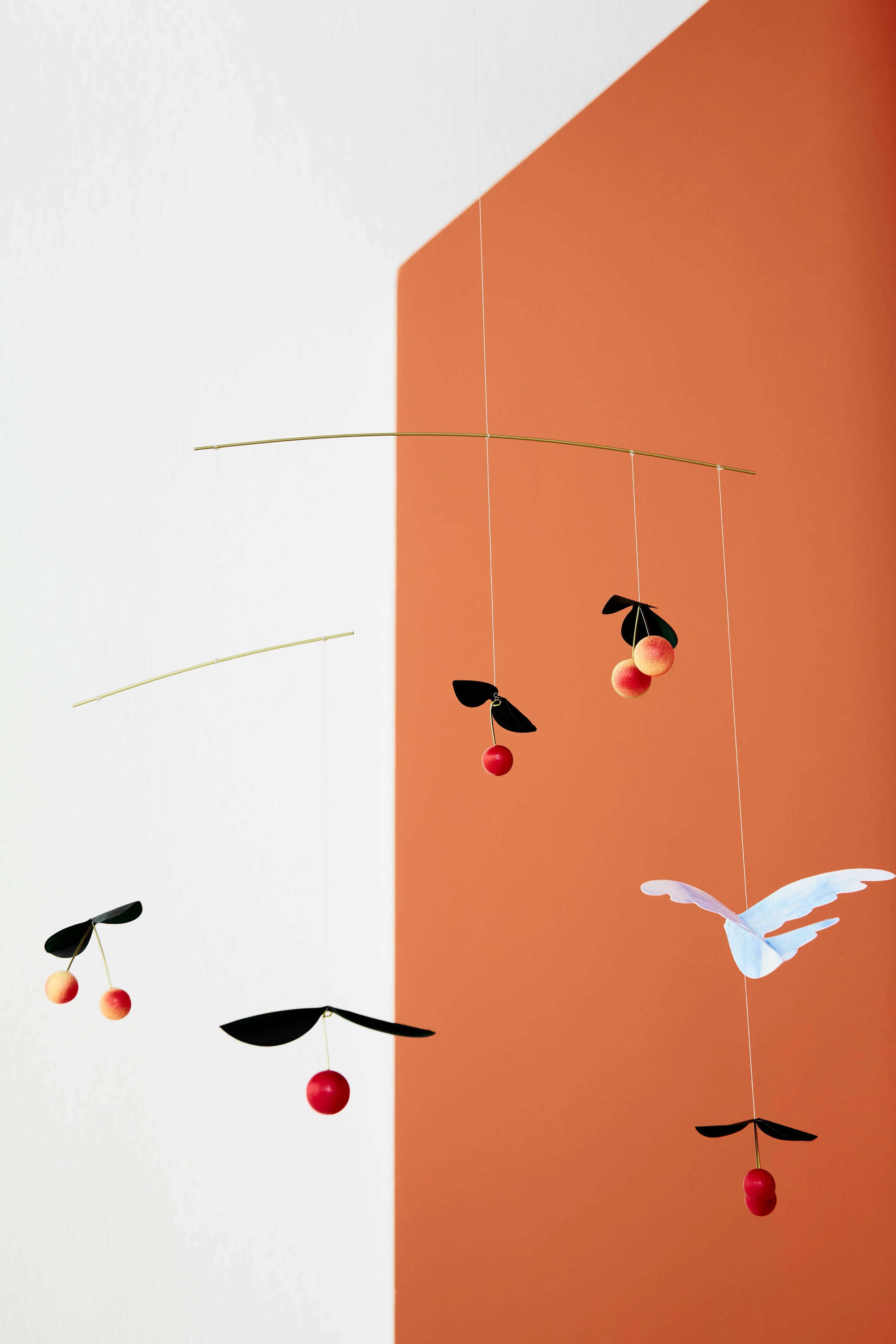 cherry and bird hanging mobile with geometric shapes on a divided background