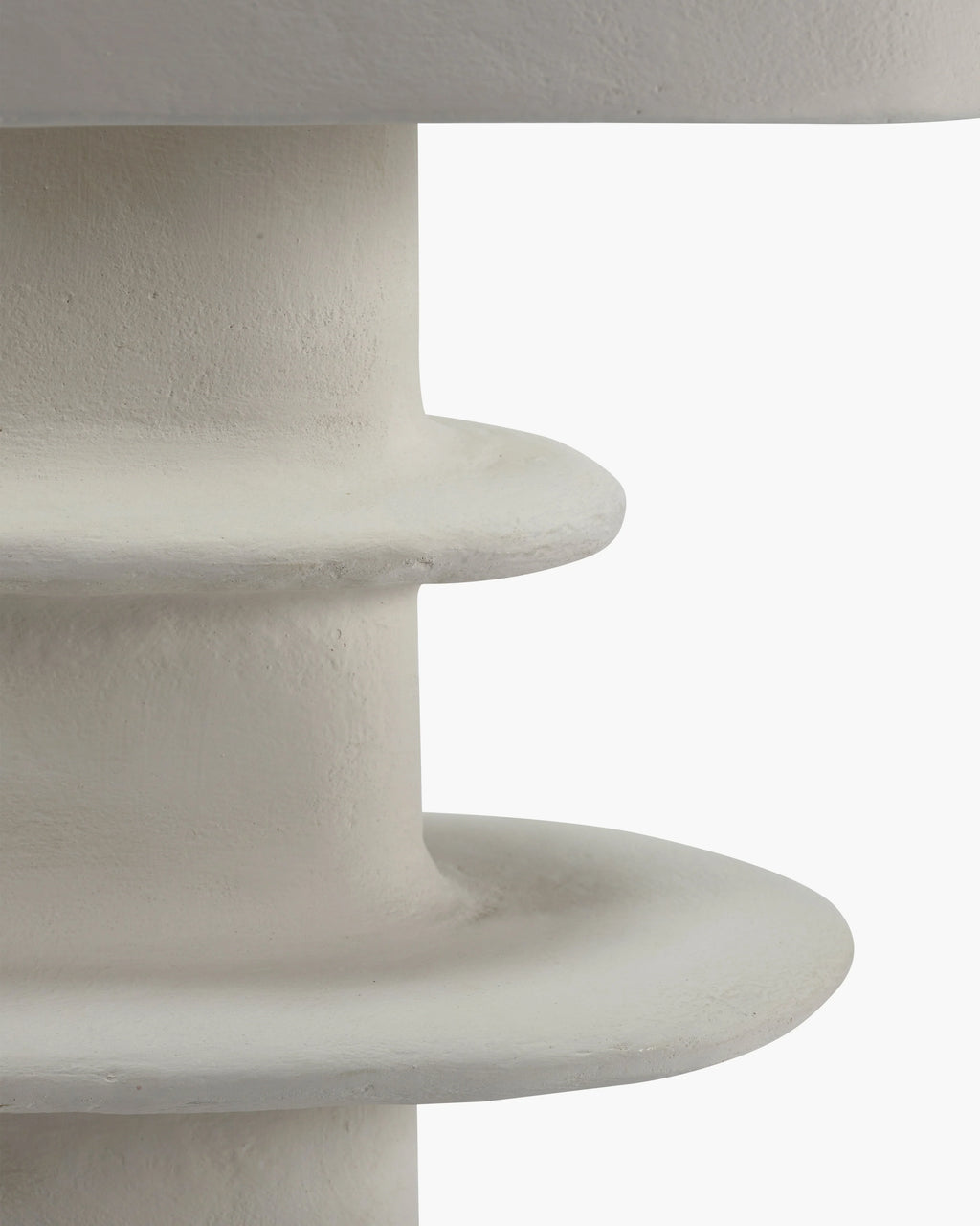 Close-up of a white paper mache table lamp showcasing its organic geometrical design and hand-sculpted base.