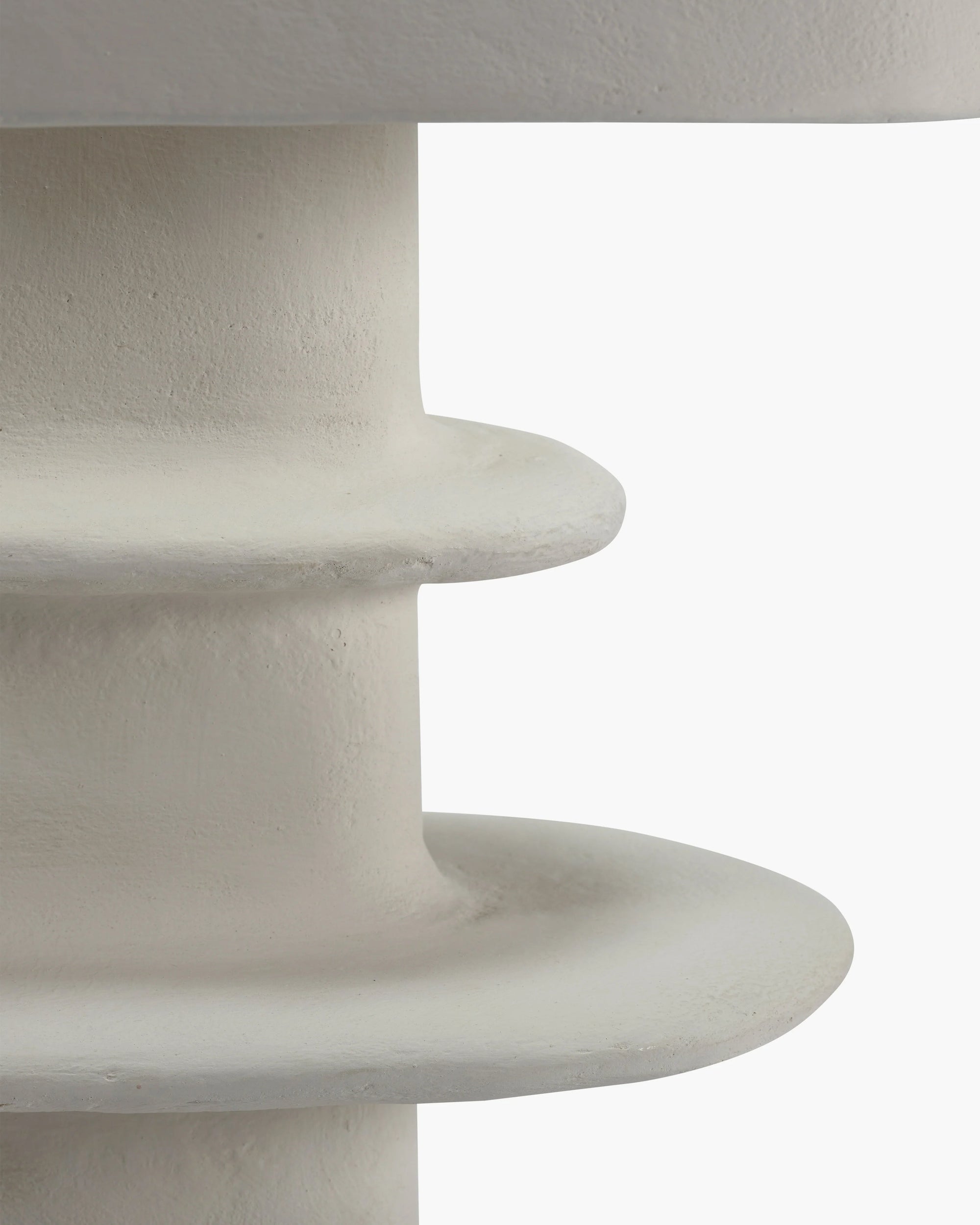 Close-up of a white paper mache table lamp showcasing its organic geometrical design and hand-sculpted base.