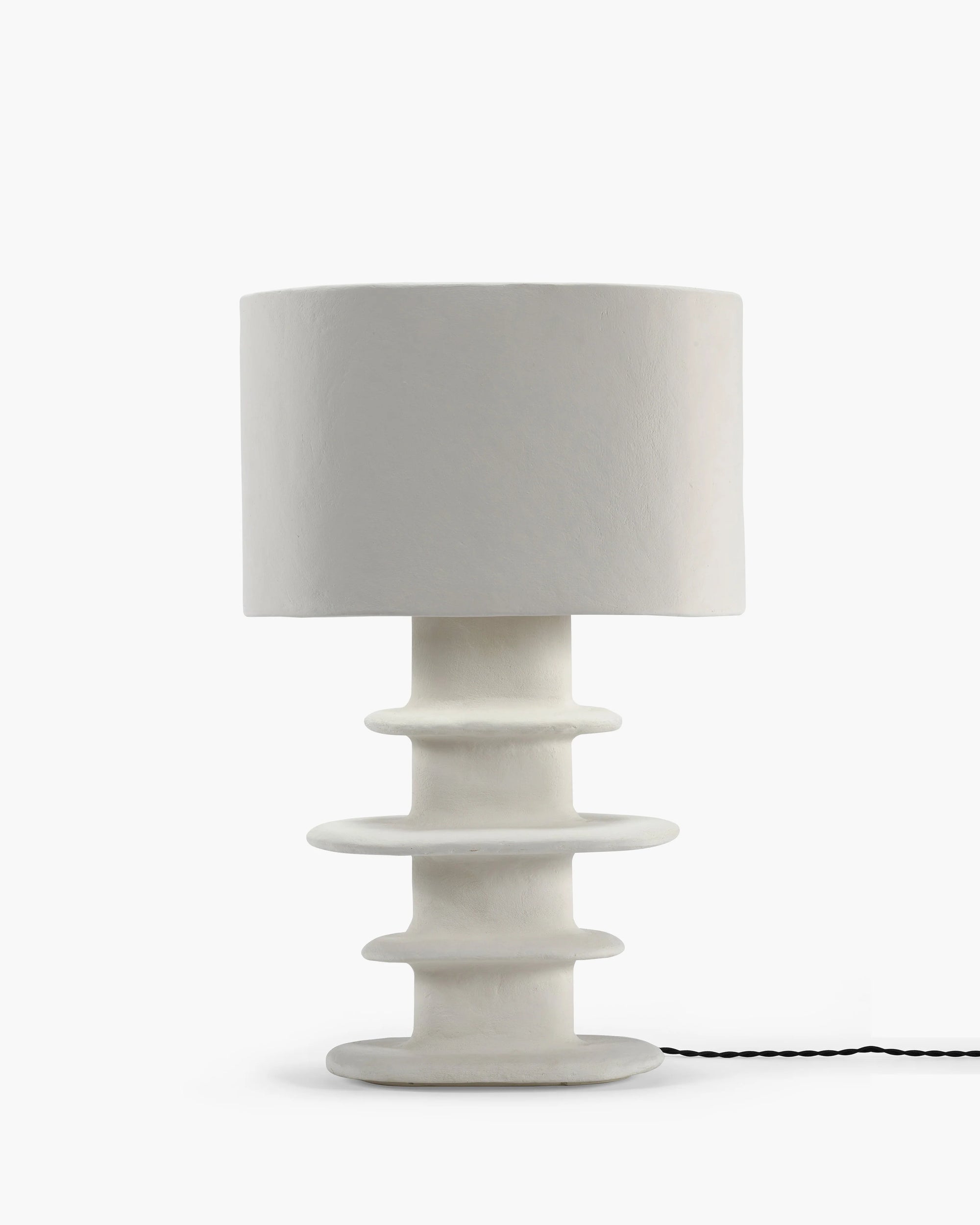 White paper mache table lamp with organic geometrical design, perfect for enhancing modern interiors.