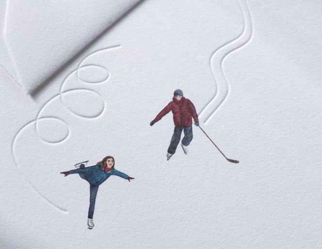 Two people ice skating on a frozen lake with a heart-shaped path.