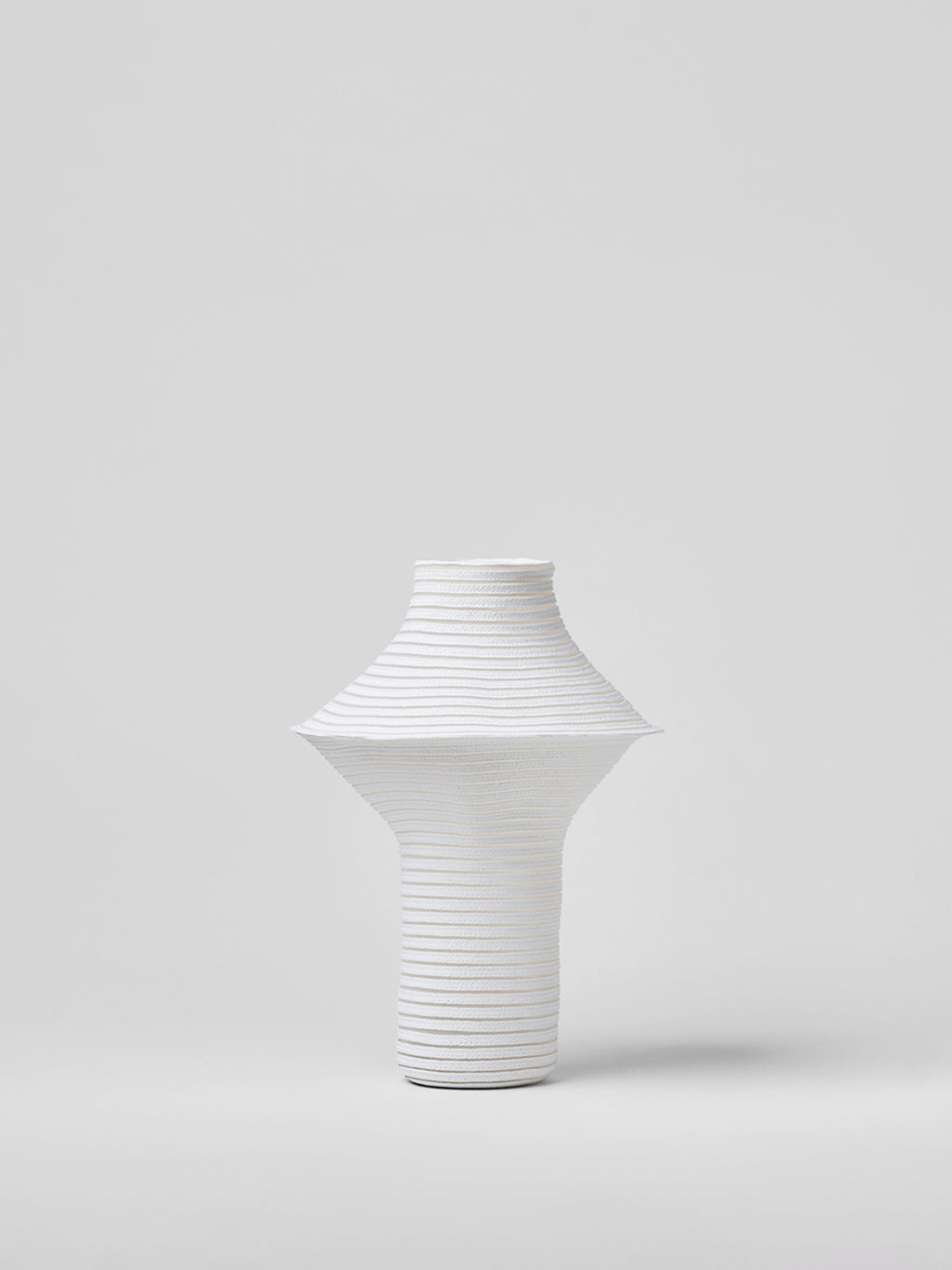 White textured paper vase on a light gray background